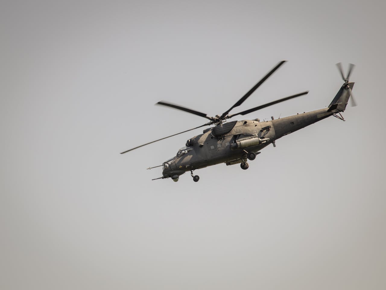 A military helicopter flying at a low angle against a clear sky in Belgrade, Serbia.