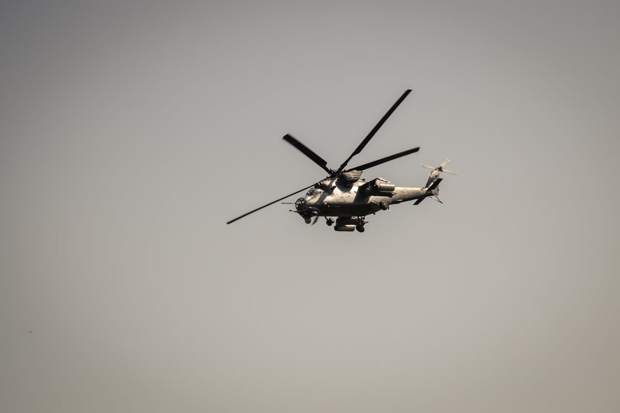 A military attack helicopter flying against a gray sky, showcasing defense technology.